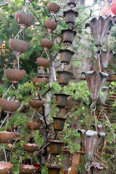 an assortment of pots and planters are hanging from the ceiling in a garden area