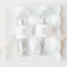 two water bottles sitting on top of a white plate