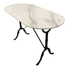 a white marble top table with black iron legs and an iron base, on a white background