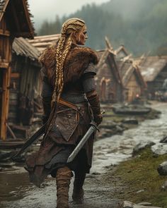 a woman with long hair and braids walking down a street in front of houses