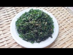 a white plate topped with greens on top of a table