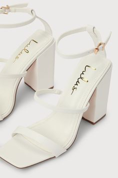 Lulus Exclusive! We just met the Lulus Mabie White Ankle Strap High Heel Sandals, and we're going crazy for how chic they are! Smooth faux leather shapes a square toe upper, a toe strap, and a vamp strap (with a bit of elastic at the side) that rises to an adjustable ankle strap with a shiny gold buckle. A trendy block heel makes these sandals easy to strut your cute self! 4. 25" wrapped block heel. Cushioned insole. Rubber sole has nonskid markings. Man made materials. Imported. Lulus | Mabie W Chic Square Toe Heels With Wrapped Heel, Party Block Heels With Heel Strap And Square Toe, Trendy Square Toe Heels With Stacked Heel, Trendy Heels With 4-inch Heel And Square Toe, Trendy 4-inch Heel Square Toe Heels, Synthetic Block Heels With 4-inch Square Toe, Trendy Heels With Sculpted Heel And Square Toe, Chic Block Heels With Single Toe Strap For Party, Trendy Block Heels With 4-inch Heel And Square Toe