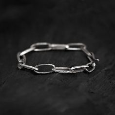 For this handcrafted oxidised paperclip bracelet, each link is cast individually in sterling silver and then oxidised to highlight its handmade quality. The unique texture and artisan quality of the oxidises silver enhance the timeless design of the classic paperclip bracelet, adding a bold and edgy twist. Unlike mass-produced pieces, this bracelet showcases the detailed craftsmanship that makes it truly one-of-a-kind. Perfect for those who love a bit of contrast and character in their jewelry, Minimalist Handmade Link Bracelets, Minimalist Handmade Link Bracelet, Handmade Minimalist Link Chain Bracelet, Handmade Minimalist Link Bracelet, Oxidized Finish Sterling Silver Link Bracelet As Gift, Silver Paperclip Chain Bracelet With Rectangular Links, Modern Oxidized Link Chain Bracelet, Silver Chain Bracelet With Adjustable Rectangular Links, Sterling Silver Oxidized Link Chain Bracelet