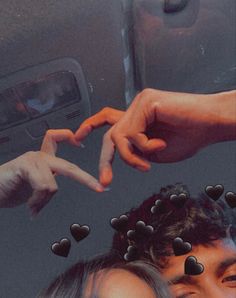 two people reaching out to touch each other's fingers with hearts on their fingers