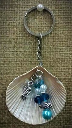 a seashell keychain with sea shells and pearls on it's side