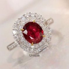 a ring with a large red stone surrounded by small white and yellow diamond halos