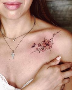 a woman with a cross and flowers tattoo on her chest