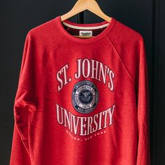 Inspired by vintage St. John’s gear you might’ve seen on the F train back in the day, we put our spin on a classic, collegiate crewneck. While the university is most commonly associated with Queens, where you’ll find its main campus, the university was founded in Brooklyn and expanded into Queens in 1954. As time progressed, the small university made a name for itself beyond its size, further opening campuses across the city. Products are mocked up on a size S. Graphics may appear smaller on lar Collegiate Crew Neck Top For Campus, University Red Varsity Crew Neck Sweatshirt, University Red Varsity Sweatshirt With Crew Neck, Collegiate Sweatshirt With University Logo, Red Collegiate Sweatshirt With Ribbed Cuffs, University Red Cotton Sweatshirt For College, Collegiate University Red Sweatshirt For Game Day, University Red Crew Neck Sweatshirt For Game Day, University Red Sweatshirt With Letter Print For College