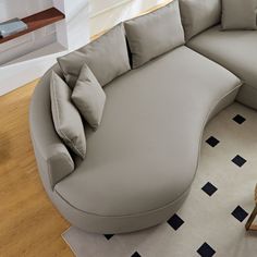 a large gray couch sitting on top of a wooden floor next to a coffee table