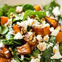 a white bowl filled with spinach and sweet potato salad