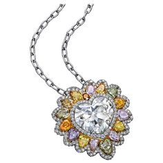 A colorful pendant necklace, showcasing a 10.02 carats heart shape diamond certified by GIA as M color and VS2 clarity, set on a five prong setting. Accented by a lion's mane of fancy color diamonds and finished with halos of round brilliant cut diamonds. Fancy color diamonds weigh 5.26 carats total, and white diamonds weigh 1.28 carats total. Finely made with a platinum mounting.  Roman Malakov is a custom house, specializing in creating anything you can imagine. If you would like to receive a Contemporary Engagement Rings, Lion's Mane, Unique Pendant Necklace, Platinum Diamond Rings, Lion Mane, Halo Pendant, Heart Shaped Diamond, Pear Shaped Diamond, Unique Pendant