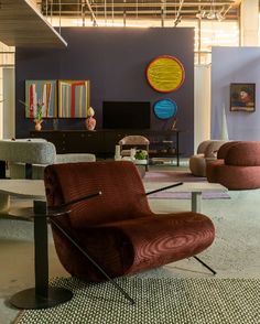 a living room filled with lots of furniture next to a painting on the wall and floor