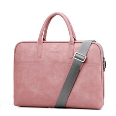 a pink laptop bag sitting on top of a white table next to a gray strap