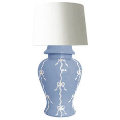 a blue and white ceramic lamp with a white shade on the top, sitting against a white background