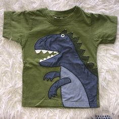 a toddler's t - shirt with a dinosaur on it