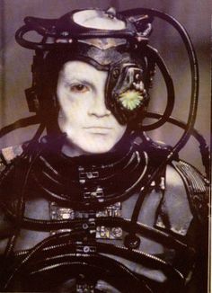 a man in a futuristic suit with many wires attached to his head