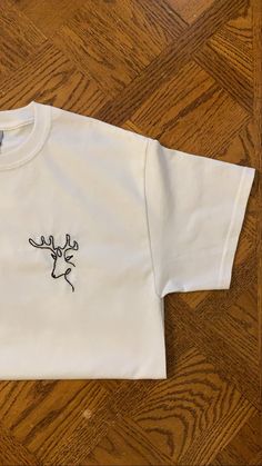 Hand Embroidered T-Shirt White Embroidered Crew Neck Shirt, Casual Tops With Contrast Embroidery And Crew Neck, Casual Crew Neck Top With Contrast Embroidery, White Short Sleeve Shirt With Custom Embroidery, White T-shirt With Machine Embroidery, Short Sleeve, White Short Sleeve Shirt With Embroidered Text, White Short Sleeve Top With Custom Embroidery, White Crew Neck Tops With Machine Embroidery, White Crew Neck Shirt With Embroidered Text