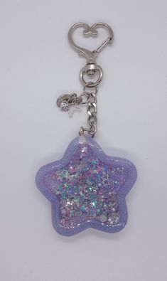 a purple key chain with a star shaped object on it's end and a heart in the middle