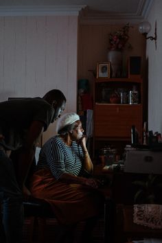 two people in a dark room one is on the phone