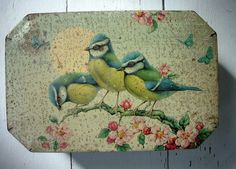 two birds on a branch with flowers painted on the side of a wooden wall hanging