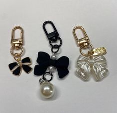 three different types of key chains with bows, pearls and bells on each one side