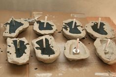 several pieces of pottery sitting on top of a wooden table covered in black and white paint