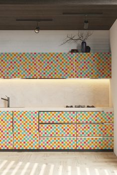 a kitchen with multicolored tiles on the wall and cabinets in front of it