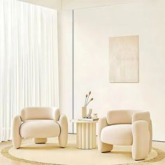 a living room with two white chairs and a round table in front of a window