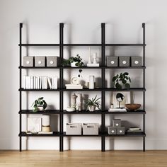 an empty room with shelves filled with plants and books on the wall next to a wooden floor