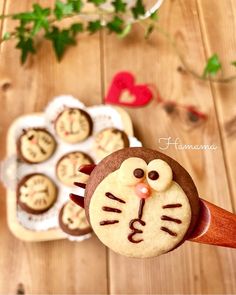 a cupcake decorated like a cat on top of a wooden table