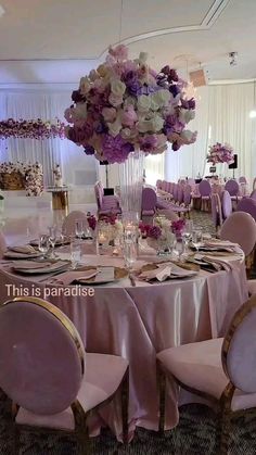 there is a table set up with purple and white flowers