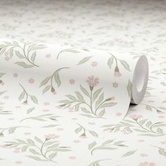 a white wallpaper with pink flowers and green leaves on the top, next to a roll of toilet paper