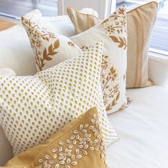 the pillows are all lined up on the bed in front of the window sill