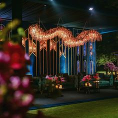 a room with chandeliers hanging from it's ceiling and flowers in the foreground