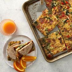 a tray with slices of pizza on it next to an orange slice and some juice