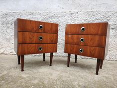 pair of mid century modern walnut dressers with chrome knobs on each drawer, side by side