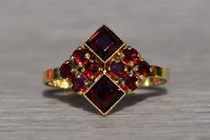 The Amwell: Ladies Signed 14K Mid Century Cocktail Ring set with Garnet. Crafted in 14 karat yellow gold is this vintage mid century styled ring set throughout with garnets. From North to South, you will see two square emerald cut garnets bezel set and decorated with fine milgrain. To the left and right are four round cut diamonds on either side. Currently the ring is a finger size 6.5 and is able to be resized for an additional fee upon request. Garnet Engagement Ring, Vintage Gold Rings, Lapis Lazuli Ring, Ruby Engagement Ring, Garnet Ring, Yellow Gold Chain, Beaded Hoops, Garnet Rings, Pendant Rings