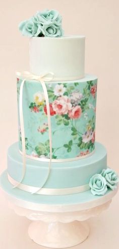 a three tiered cake decorated with flowers and ribbons