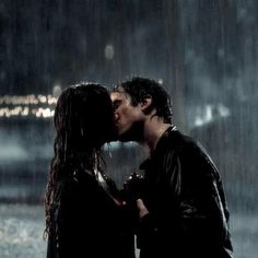 a man and woman kissing in the rain