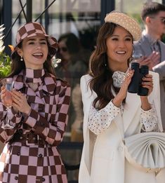 two women standing next to each other holding wine glasses