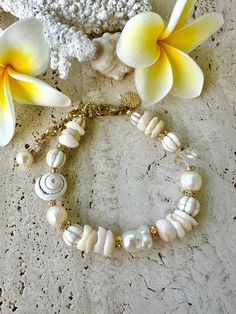 Large freshwater baroque pearl in the centre following through with shells, crystals white howlite stones and a large conch shell, attached with a gold crab claw clasp, extra chain for sizing.  8.5 inches long White Pearl Bracelet With Charm For Beach, White Beaded Shell-shaped Bracelets, White Shell Oyster Bracelet, White Baroque Pearl Jewelry With Natural Stones, Shell-shaped White Pearl Chain Jewelry, White Shell-shaped Pearl Chain Jewelry, White Shell With Pearl Charm, White Pearl Chain Jewelry, Shell-shaped, Elegant Shell-shaped Bracelets