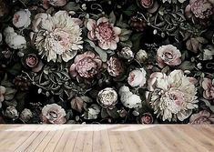 an empty room with flowers on the wall and wood flooring in front of it