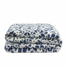 the blue and white leopard print blanket is folded up on top of each other,