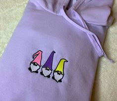 Super cute and fun embroidered gnome hoodie! This sweatshirt is a women's large and has trendy small side slits at the bottom. This is a perfect and flattering gift for a friend, daughter, girlfriend, or yourself! I made this myself and it took a total of 1 hour and 30 minutes, but it was 100% worth it! Find more looks and make a custom hoodie on my Instagram - embroideredbyaralyn This one listing is on sale because it was pre made for the pictures. It is a size large and is available to ship to Embroidered Gnome, Sweatshirt Patchwork, Butterfly Crewneck, Patchwork Ideas, Custom Hoodie, Gift For A Friend, Soft Hoodie, New Trailers, Custom Hoodies