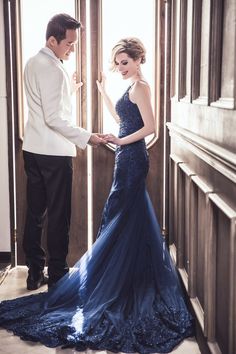 a man standing next to a woman in a blue dress