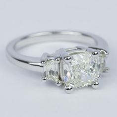 three stone engagement ring setting in white gold with diamonds on the sides and four claw prongs