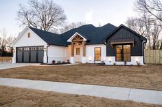 a white and black house with two garages