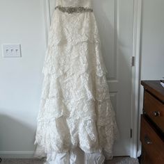 a white wedding dress hanging on a door