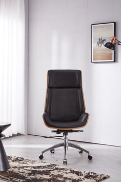 a black office chair sitting on top of a rug in front of a white wall