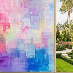 an abstract painting is displayed in front of a garden with hedges and flowers on either side